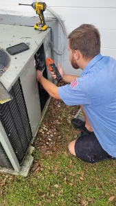 Sunshine Heating & Air Conditioning Technician servicing a outdoor HVAC unit